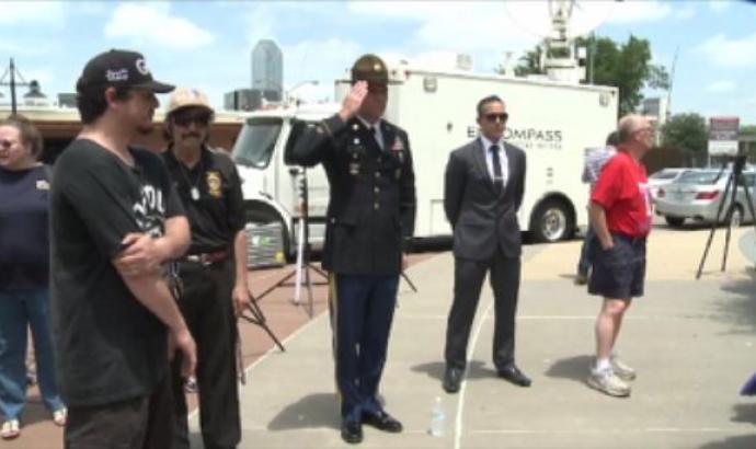 Mourners offer their condolences at a memorial set up in front of the Dallas Police Headquarters.